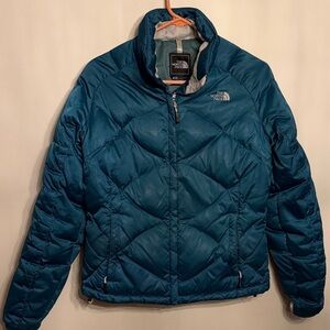 The North Face Women's Teal Puffer Jacket. Durable and stylish design.